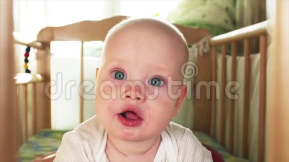 一张漂亮蓝眼睛6个月小男孩看着某人的慢镜头画像视频的预览图