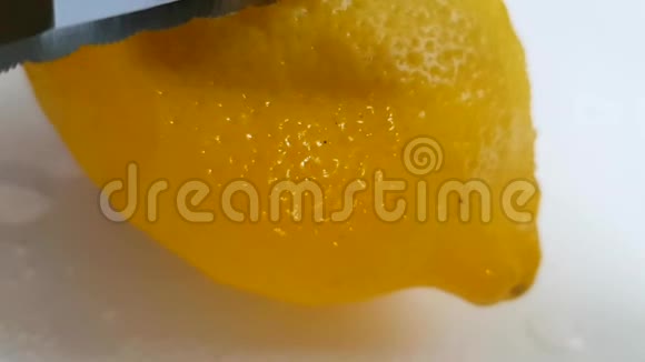 柠檬刀柠檬酸切割白色背景慢镜头视频的预览图