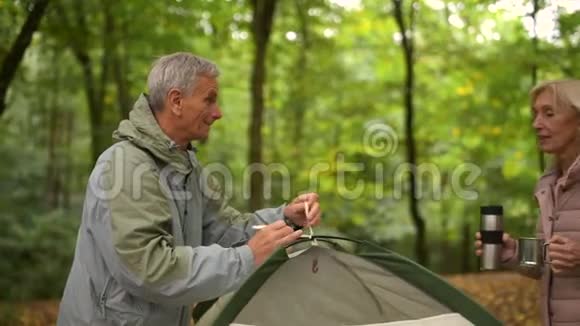 一对快乐的老人完成了帐篷的搭建视频的预览图