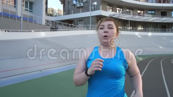 在体育场跑道上跑步的有着多大身材的女人视频的预览图