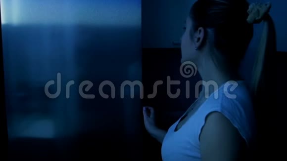 穿睡衣的年轻女子拿出冰箱晚上吃苹果视频的预览图