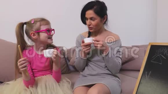 妈妈和女儿开玩笑在沙发上吃喝视频的预览图