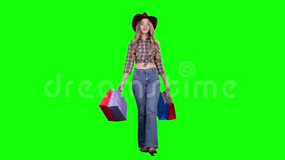 戴着帽子和牛仔靴的女孩手里拿着袋子绿色屏幕视频的预览图