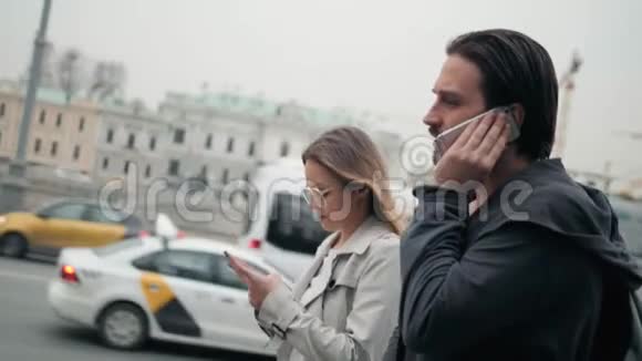 几个游客在一条城市街道上行走使用电话导航应用程序男女游客步行视频的预览图