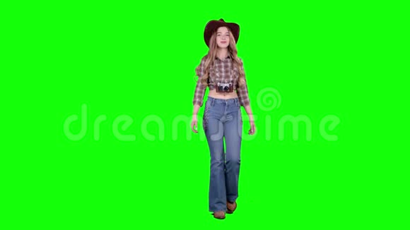 戴着牛仔帽的女孩走路拍摄美丽的建筑绿色屏幕视频的预览图