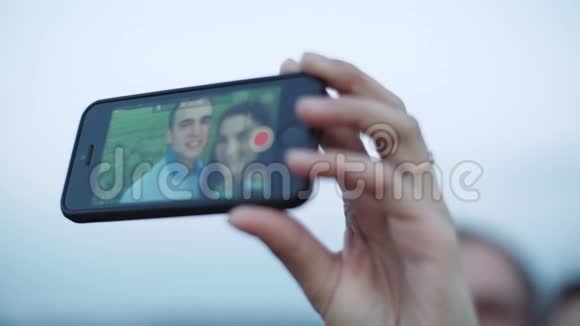 一对相爱的夫妇使用智能手机来占据自己的智能手机赛尔夫在打电话视频的预览图