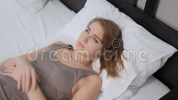 躺在床上头痛头痛的女人视频的预览图