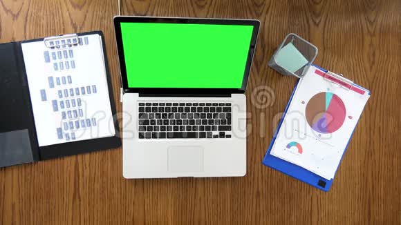 商人手在带有彩色绿色屏幕的笔记本电脑上滚动和打字视频的预览图