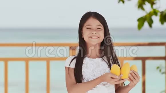 一个迷人的菲律宾女学生穿着白色连衣裙和长发手里拿着芒果太阳视频的预览图