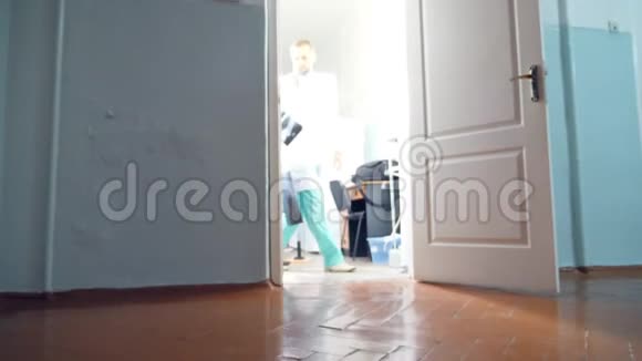 两位白种人男性医生从柜子里出来观看mri图片两名护士跟在医生后面低角度视频的预览图