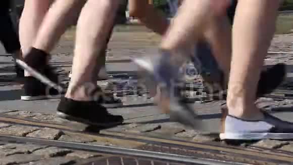 在人行横道上行走的人群的腿人群脚的特写镜头城市人群视频的预览图