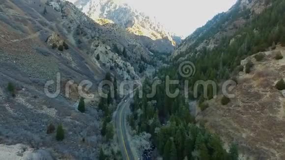 一条深峡谷道路和一辆汽车沿着这条道路行驶的高角度区域景观视频的预览图
