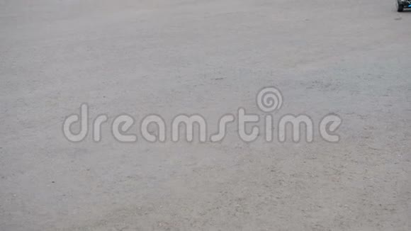 这个少年骑在沥青上的一个自平衡的两轮气垫板上腿是特写的来自视频的预览图