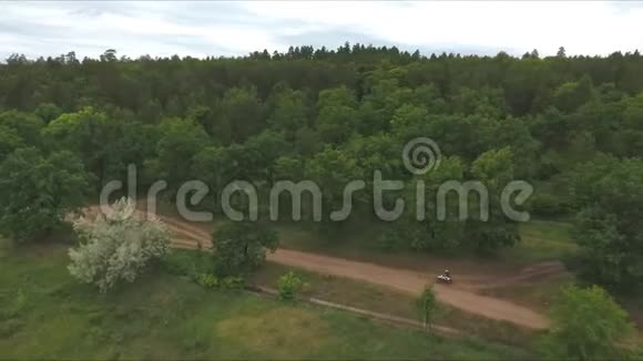 摩托车手骑在森林边的乡村公路上视频的预览图