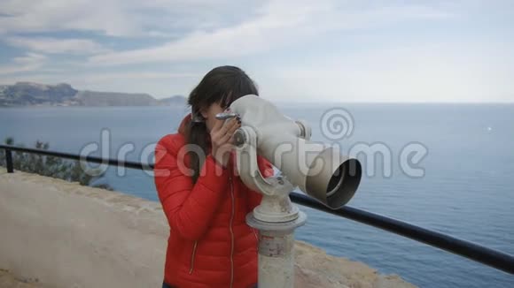 穿着红色泡泡夹克的年轻女子从海底的观察甲板上看着望远镜视频的预览图