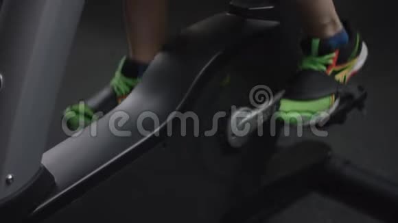 男人开始踩新的运动自行车并跟踪时间在新的健身房集中在腿上视频的预览图
