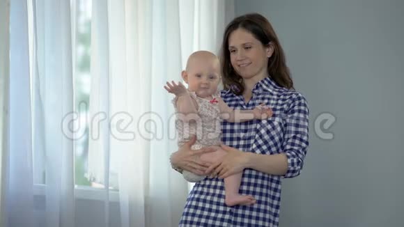 幸福的妈妈抱着可爱的女婴微笑着走进镜头做母亲视频的预览图