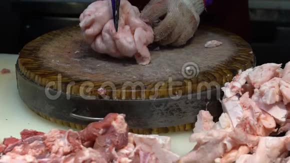 慢动手的猪肉店老板使用刀切生肉在木板上视频的预览图