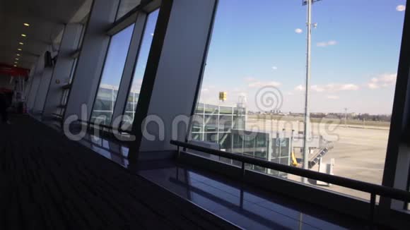 现代化的机场透过窗户可以看到美丽的跑道和客运站视频的预览图