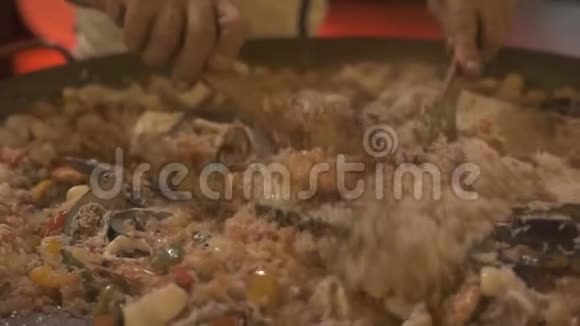 在平底锅中准备西班牙海鲜饭厨师在餐厅厨房做饭时搅拌西班牙海鲜饭视频的预览图