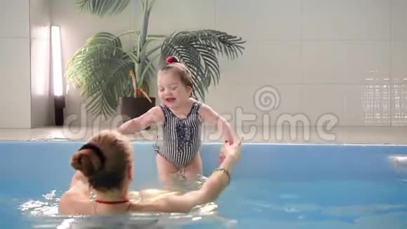 可爱的小男孩和他妈妈在游泳池里玩视频的预览图