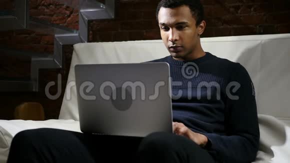 进攻思维非洲男人夜间在笔记本电脑上工作视频的预览图