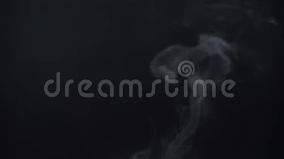 在黑色背景上缓慢地飞行的蒸汽烟雾特写镜头视频的预览图