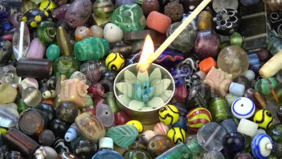 彩色印度珠子背景上的莲花形成装饰蜡烛视频的预览图