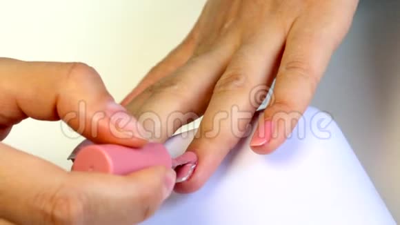 女人做指甲用刷子在指甲上刷凝胶视频的预览图
