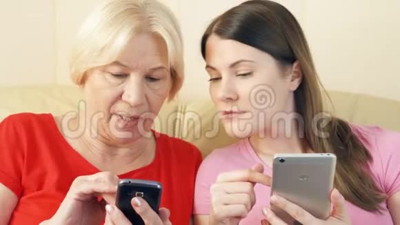 母女俩用智能手机浏览阅读新闻科技时代理念中的孤独视频的预览图