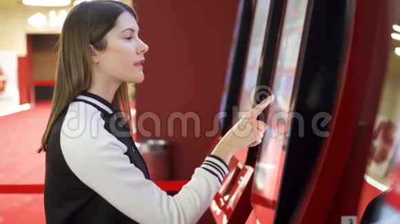 青少年从电影院的自动售货机买电影票女性通过触摸屏幕做手势视频的预览图