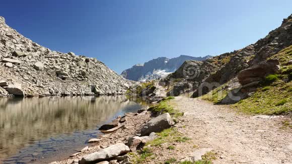 人在田园诗般的山景中以晶莹的湖水高山峰和冰川行走夏日冒险视频的预览图