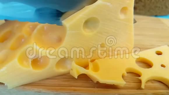 刀将瑞士奶酪有机切割在木制的慢镜头上视频的预览图