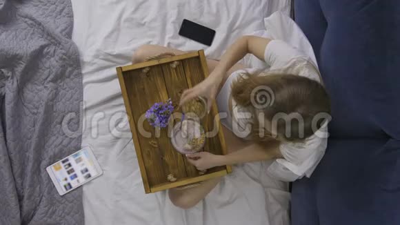 在床上吃健康早餐的顶景女士视频的预览图