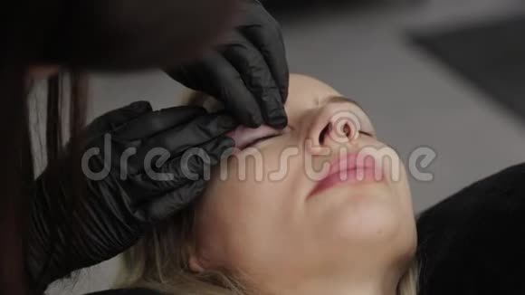 专业美容师在一家美容院胶水硅胶衬里睫毛层视频的预览图