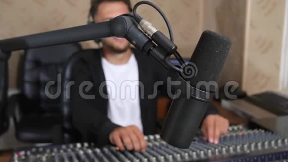 收音机主持人在耳机前的音频控制台前的无线电演播室在无焦点背景视频的预览图