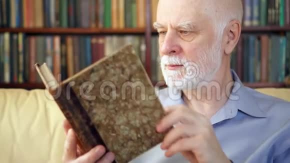 年长的老人在家放松读书享受退休生活背景中的书架视频的预览图