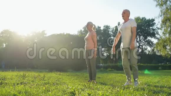 在公园里蹲着的快乐的老夫妇视频的预览图