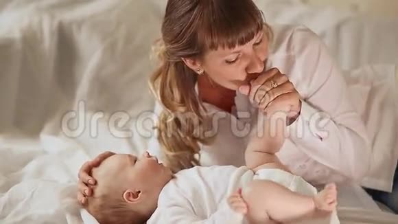 妈妈双手温柔地吻着她小宝宝的小脚视频的预览图