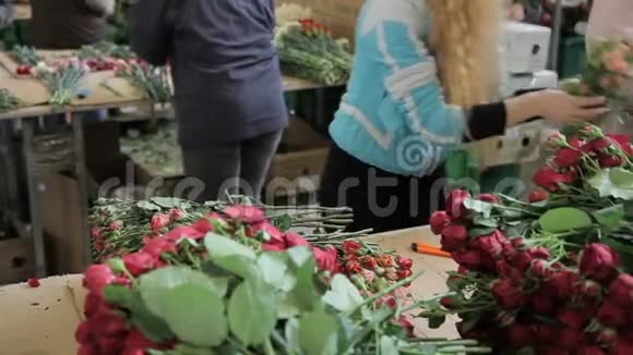 女人正拿着一束花放在街道市场开放前的桌子上视频的预览图