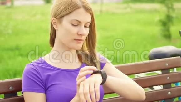女人在公园里用智能手表发短信使用她的智能手表用语音应用程序向朋友发送信息视频的预览图