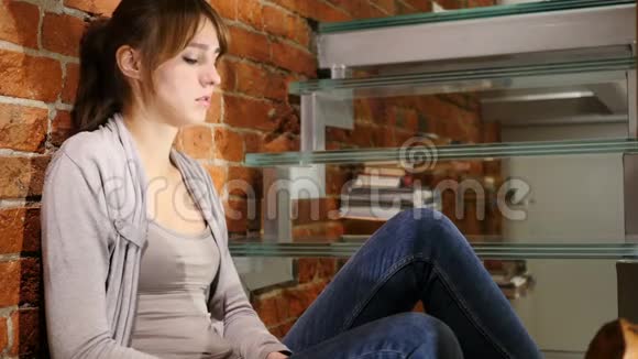 悲伤的不安和迷失的年轻女子坐在楼梯上视频的预览图