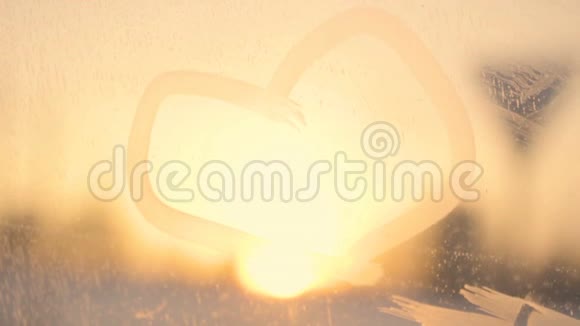 在霜冻的车窗上拖着心迎着夕阳的路在雪的冬天浪漫的心情视频的预览图