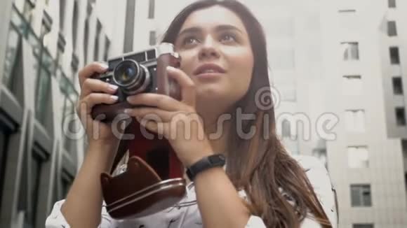 美女黑发女郎手持vinatge手动相机慢镜头视频的预览图