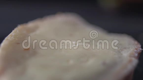 刀把一层黄油涂在一块面包上视频的预览图