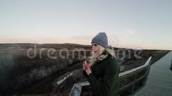 年轻快乐的女人站在桥上欣赏美丽的风景旅游女性花时间在自然上视频的预览图