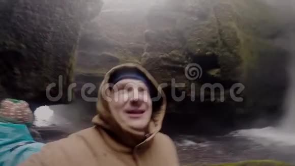 年轻的幸福夫妇一起在Gopro上自拍男人和女人欣赏冰岛的Gljufrabui瀑布视频的预览图