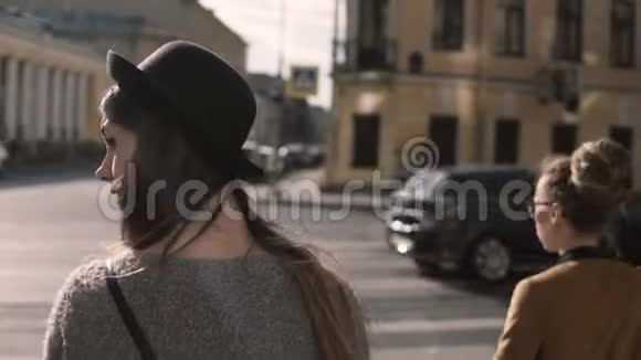 两个时髦的女人走在市中心的后景穿过马路朋友们一起度过时光视频的预览图