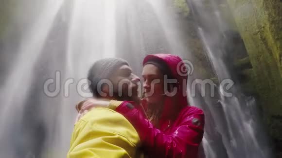年轻快乐的旅行夫妇在gopro相机上自拍冰岛的冰川瀑布男人和女人接吻视频的预览图