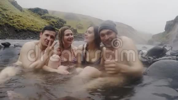 冰岛温泉地热温泉两对旅行夫妇在冰岛的热池里放松喜欢洗澡的游客视频的预览图